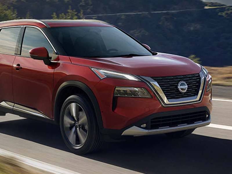 Paul Miller Nissan in Fairfield CT 2023 Nissan Rogue in red driving on a rural road