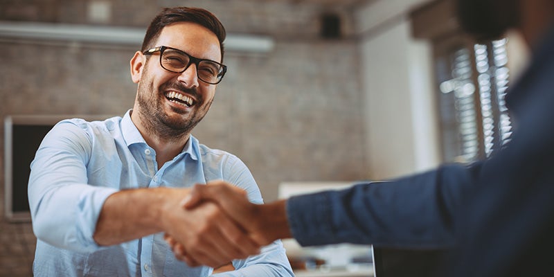 Paul Miller Nissan in Fairfield CT customer shaking hands with sales rep
