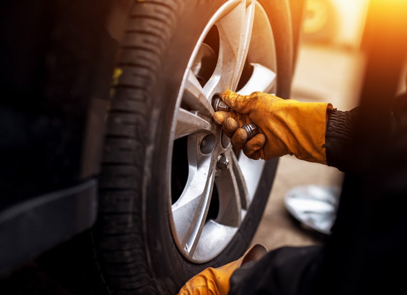 Qualified Nissan technician performing tire maintenance