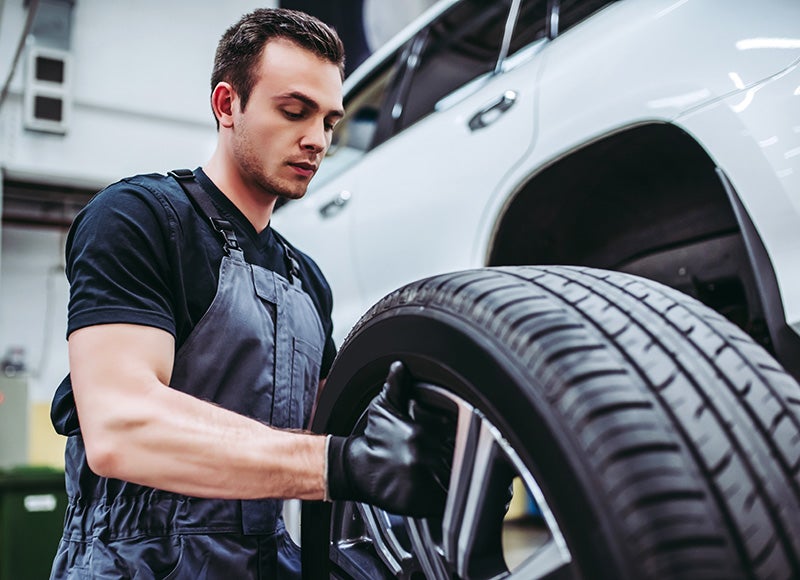 Nissan Tire Service with technician repairing a tire